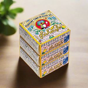 Three stacked fishwife tuna boxes with colorful labels on a kitchen table with green leaf in back