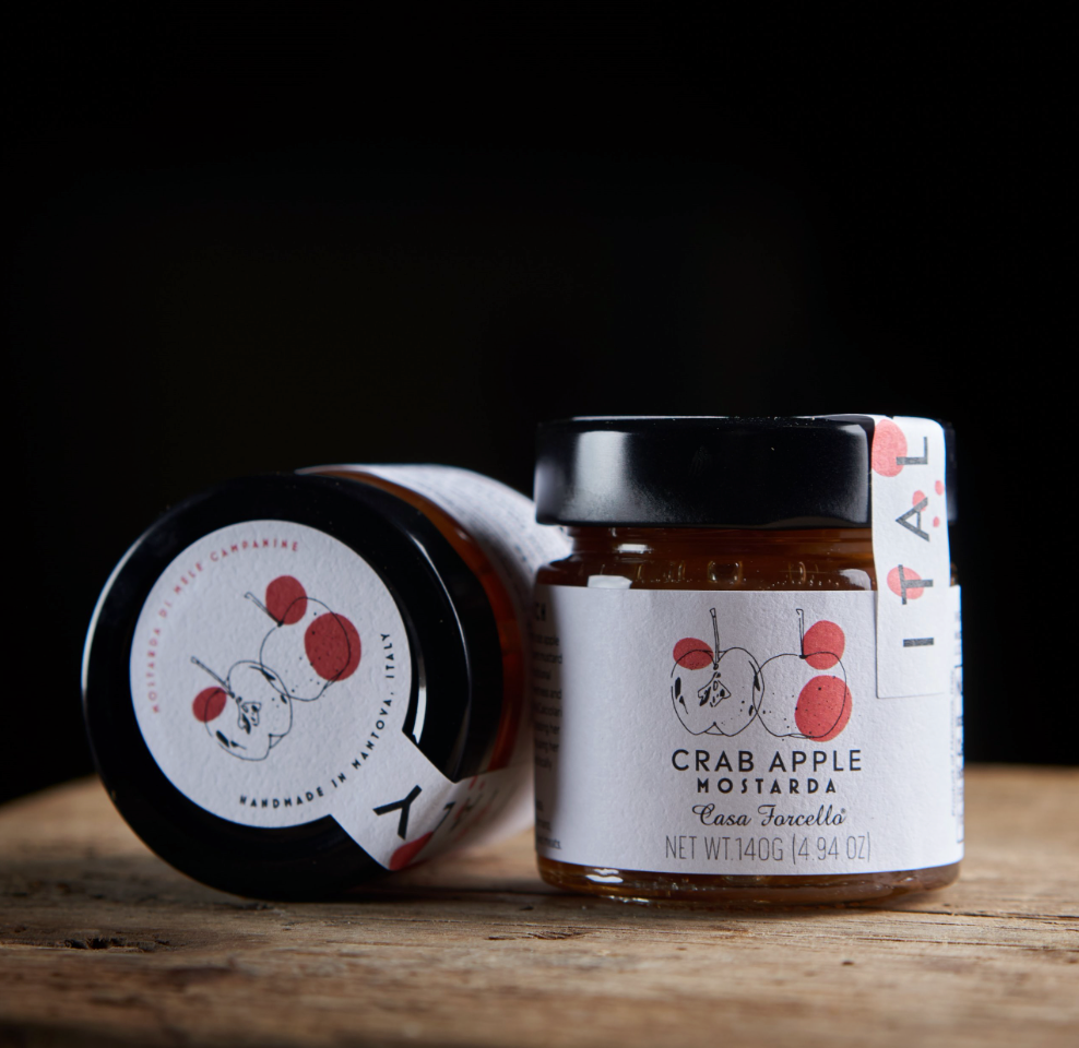 Jar of crab apple mustard with a visible label on a wooden surface