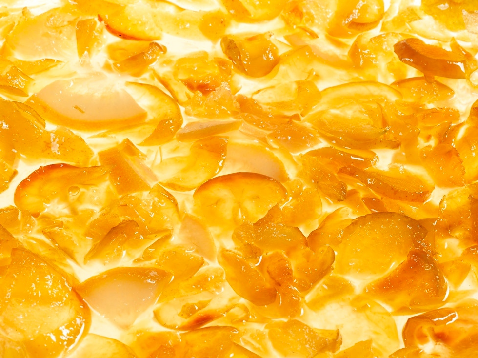 Close-up of crab apple mustard with a glossy texture, slices of apple in a yellow/orange jelly