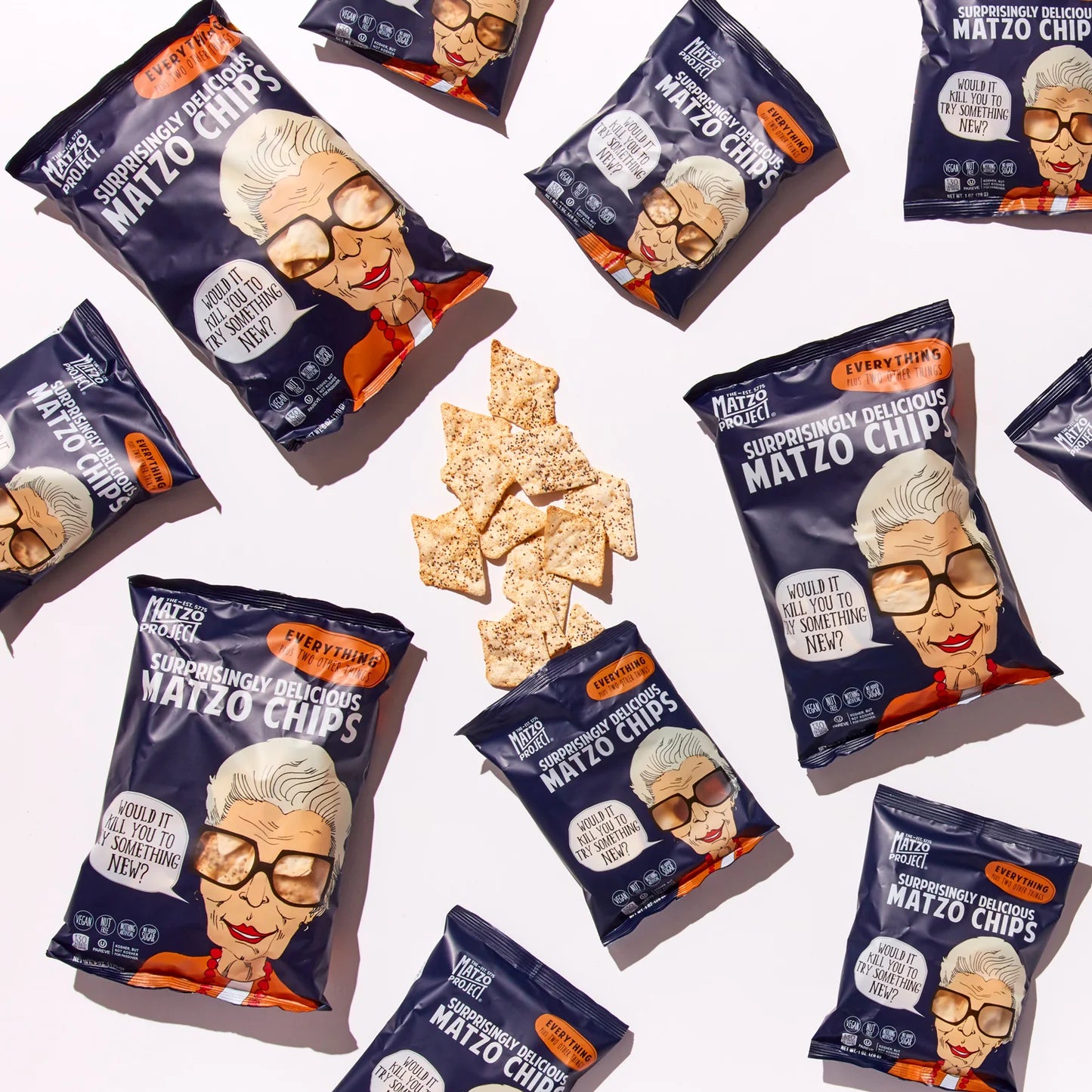 Packages of 'Surprisingly Delicious Matzo Chips' with a Grandma character design on a white background. Matzo chips in center of image. Everything Flavor