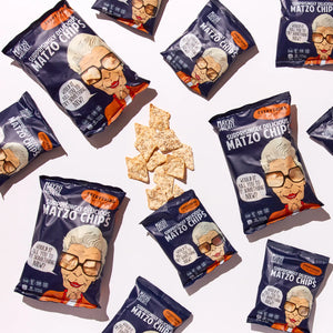 Packages of 'Surprisingly Delicious Matzo Chips' with a Grandma character design on a white background. Matzo chips in center of image. Everything Flavor