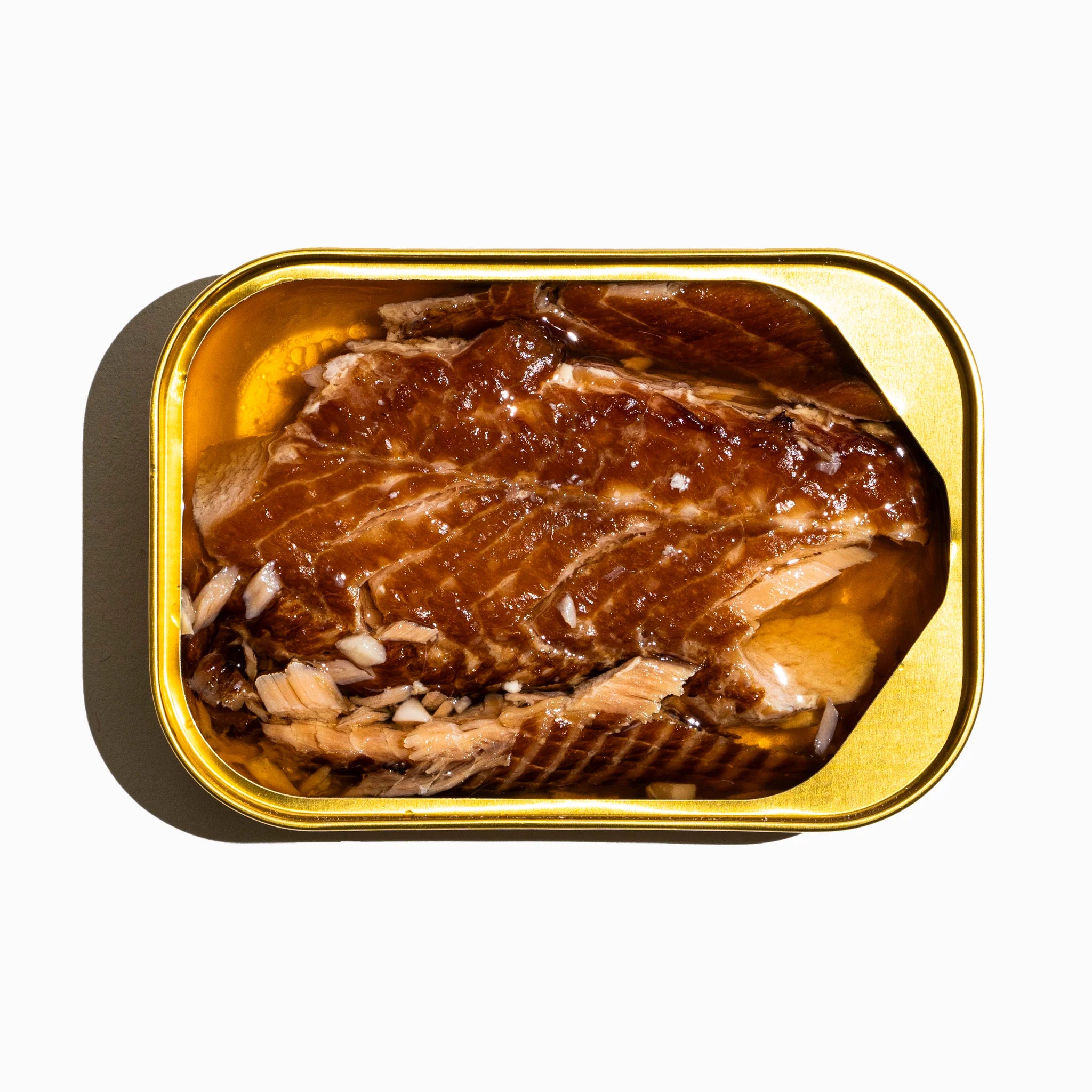 Tin of canned trout open, on a white background