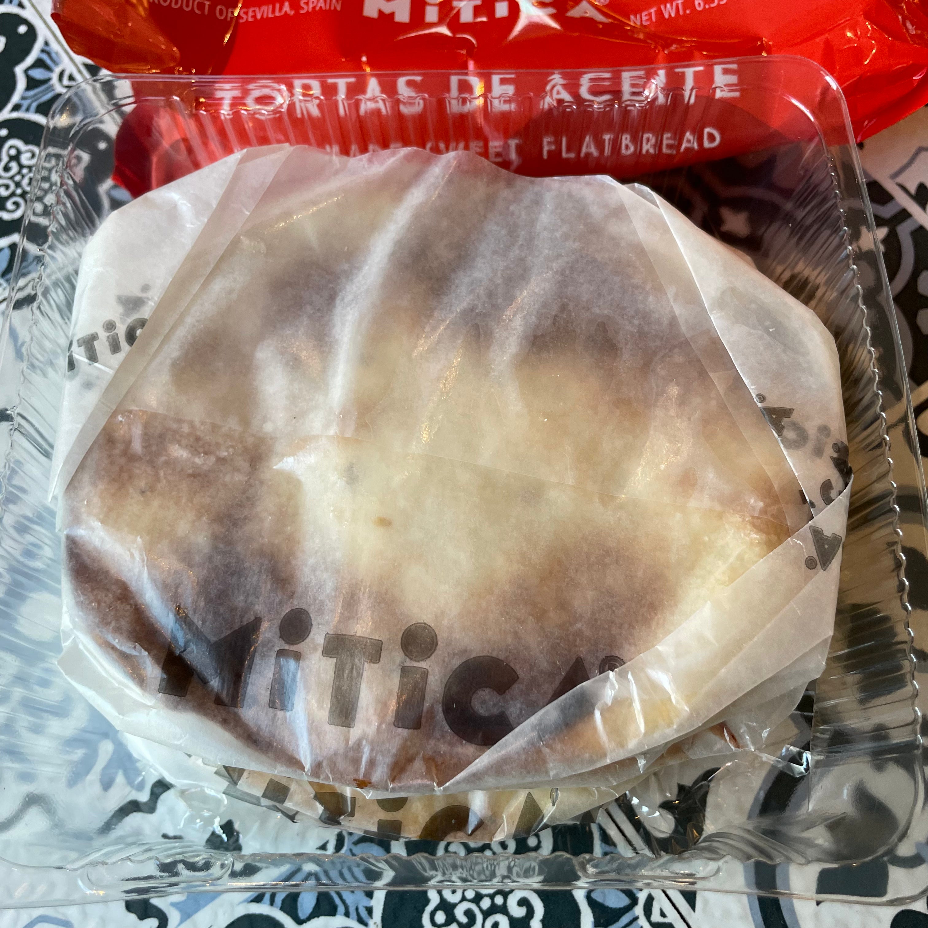 Individually packaged flatbreads in wax paper, with red branded package behind