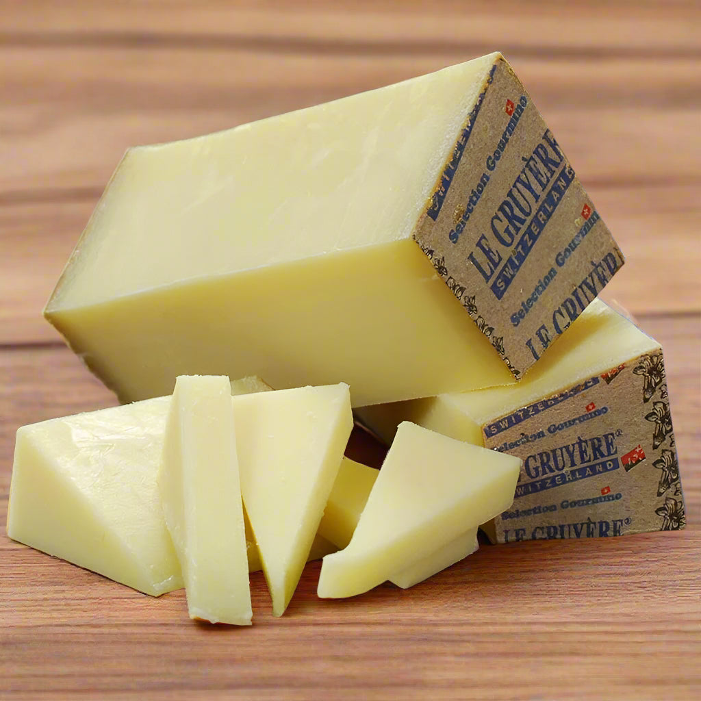 Block of yellow cheese with a few slices on a wooden surface