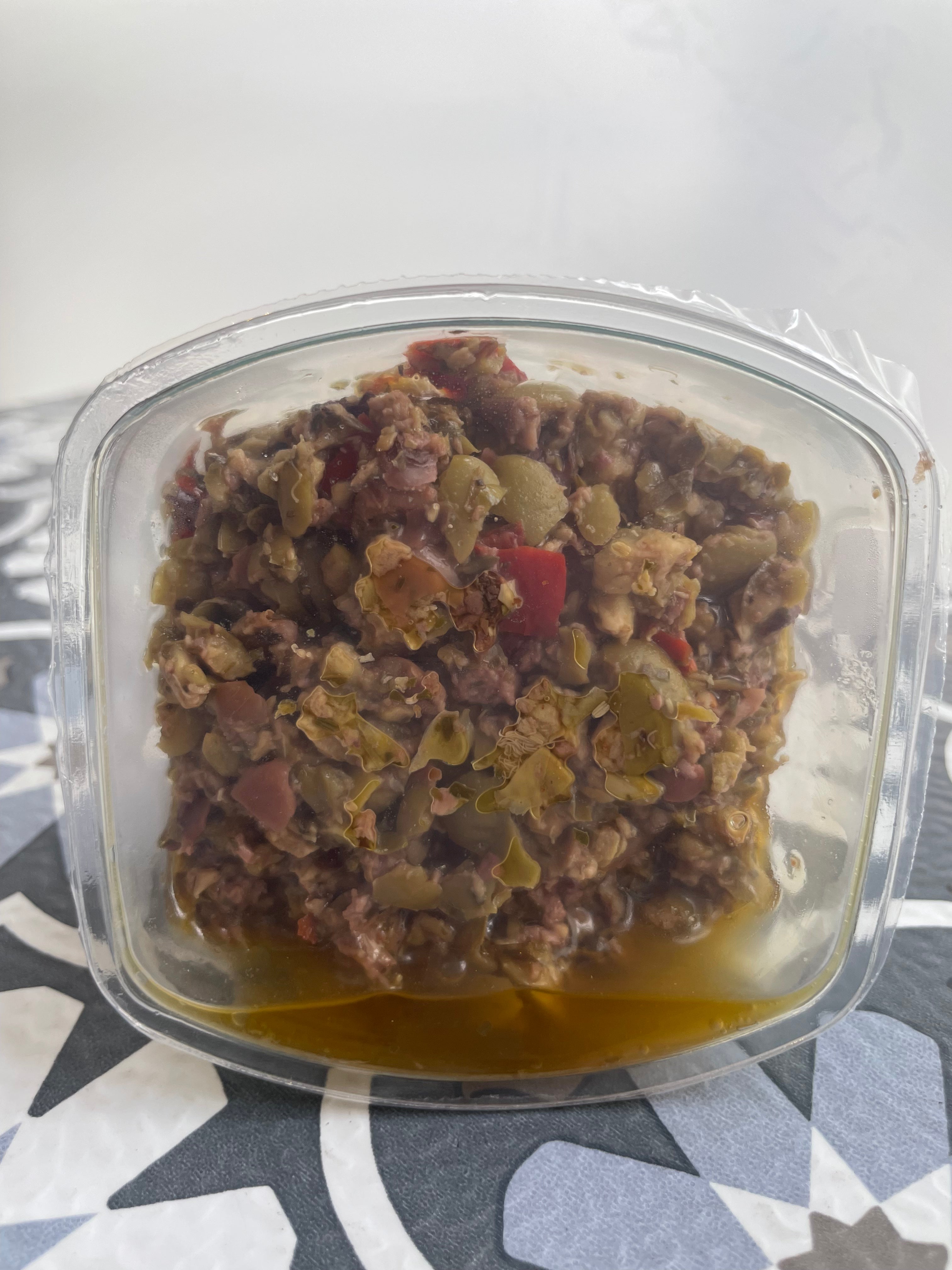 olive bruschetta in plastic container, unobstructed, top off
