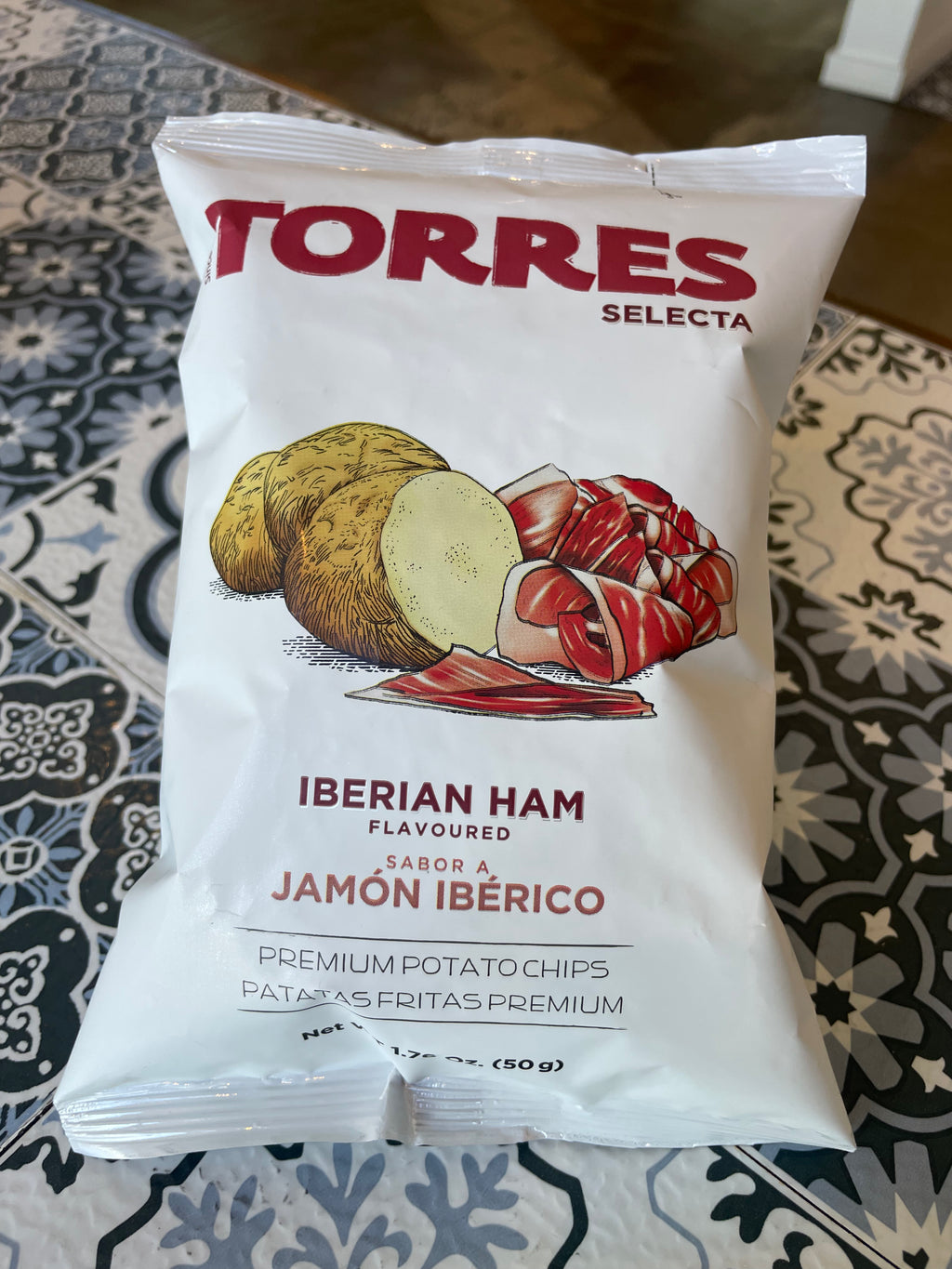 Torres Selecta Iberian Ham flavored potato chips packaging on a patterned surface