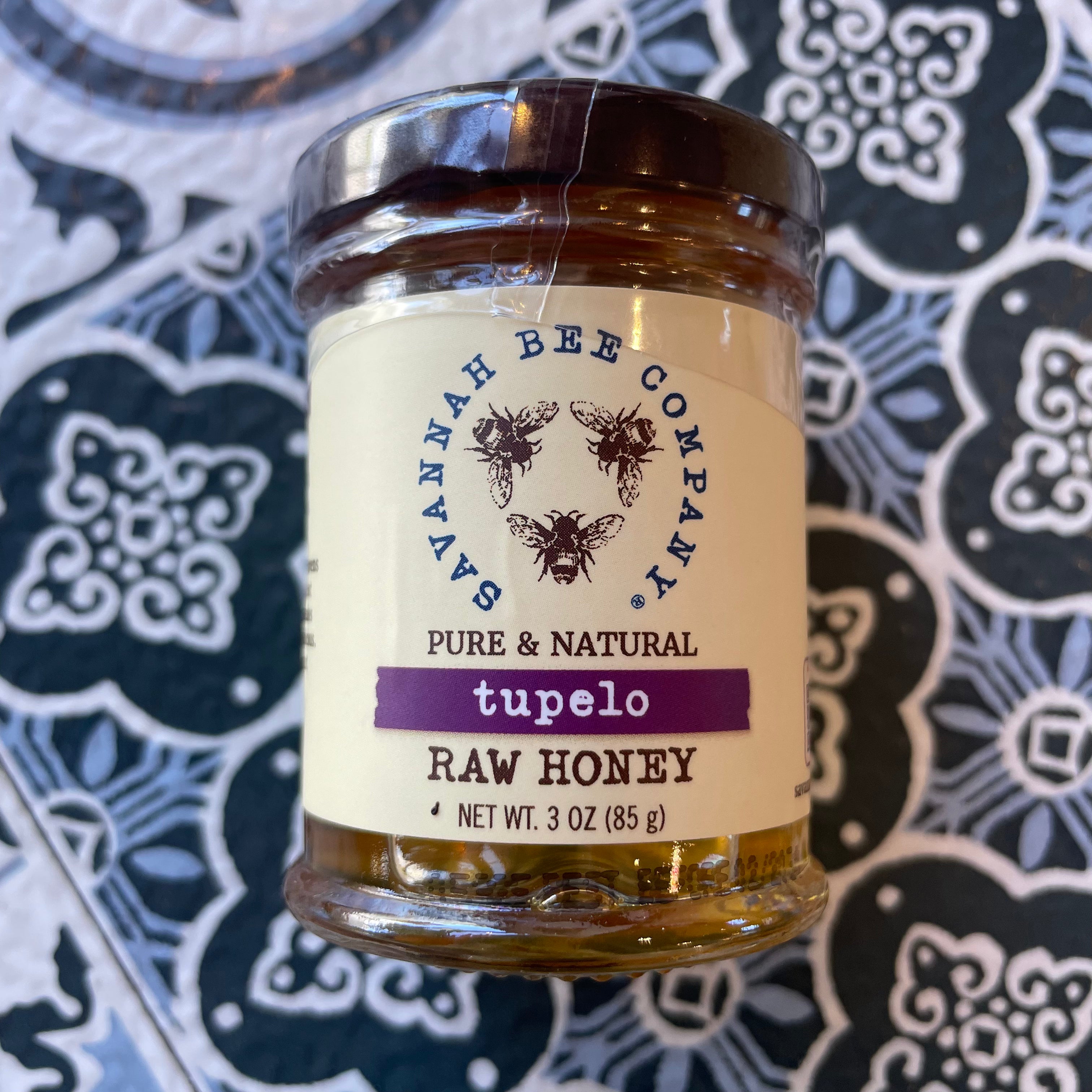 Tupelo honey - Front side showing savannah Bee Company Logo 'Raw Honey" on flower tile design