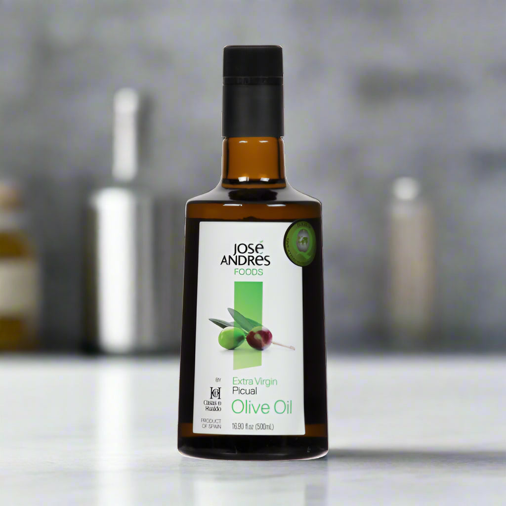 Bottle of Jose Andres Foods olive oil in glass container, on kitchen counter with grey background