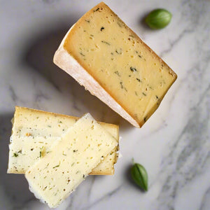 white-yellow pasted cheese, with green speckled and small holes throughout, with a bright orange rind