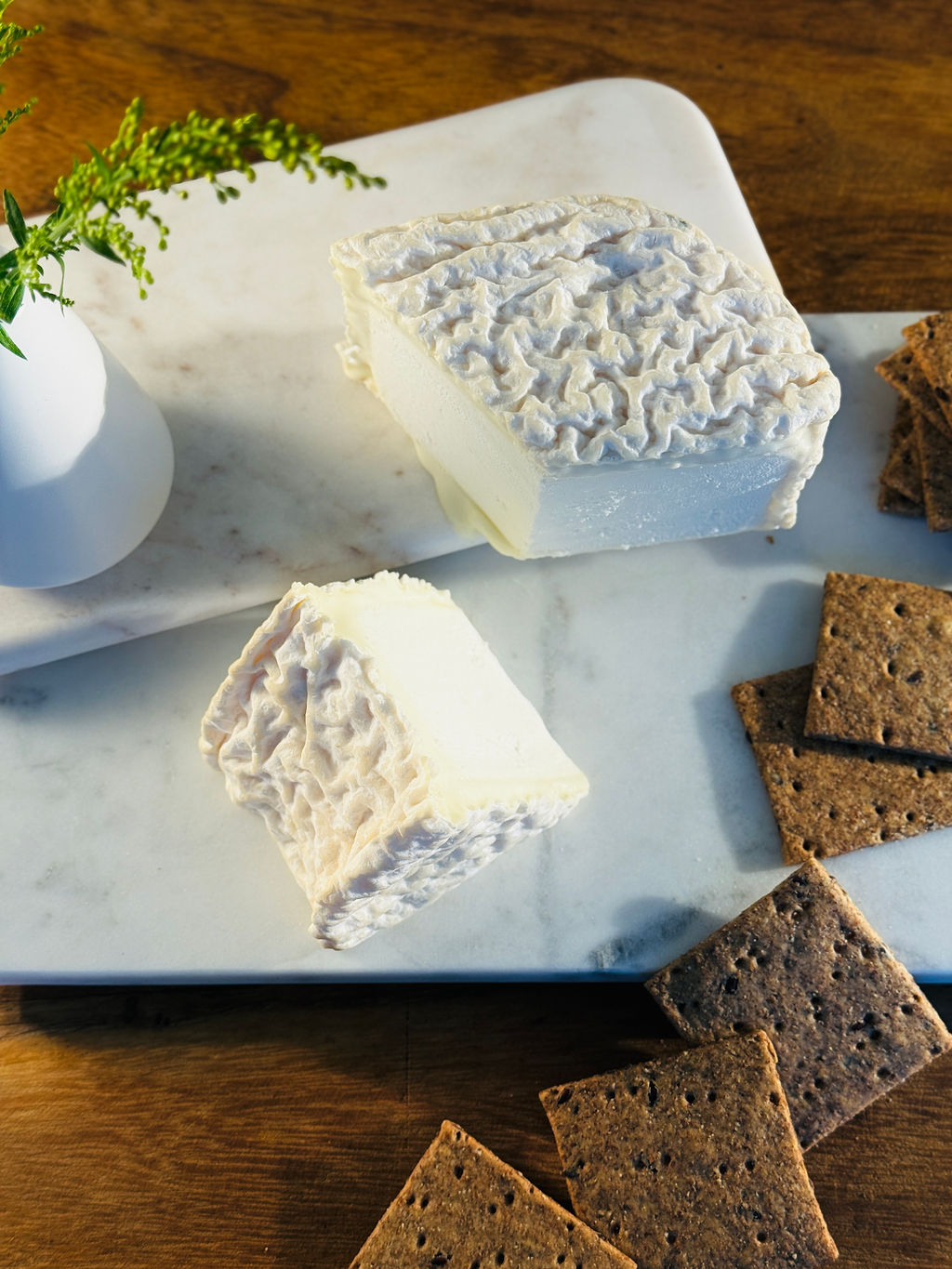 Two wedges of Shabby Shoe goat's milk cheese with crackers