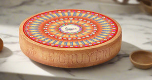 Decorative wheel of cheese with colorful design on a kitchen marble table background