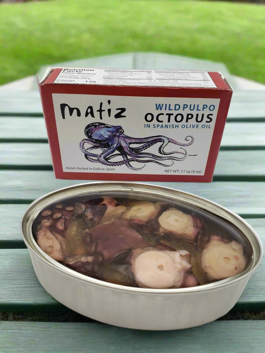 can of tinned octopus with lid off, in oil oil and sea salt, with retail packaging behind