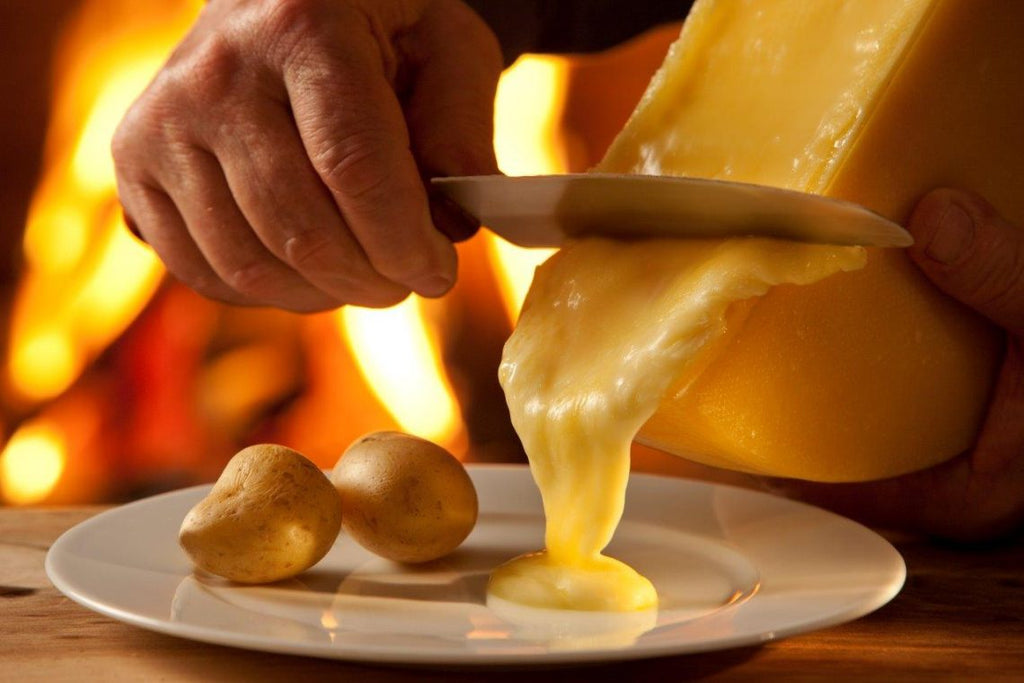 Raclette cheese being melted over potatoes