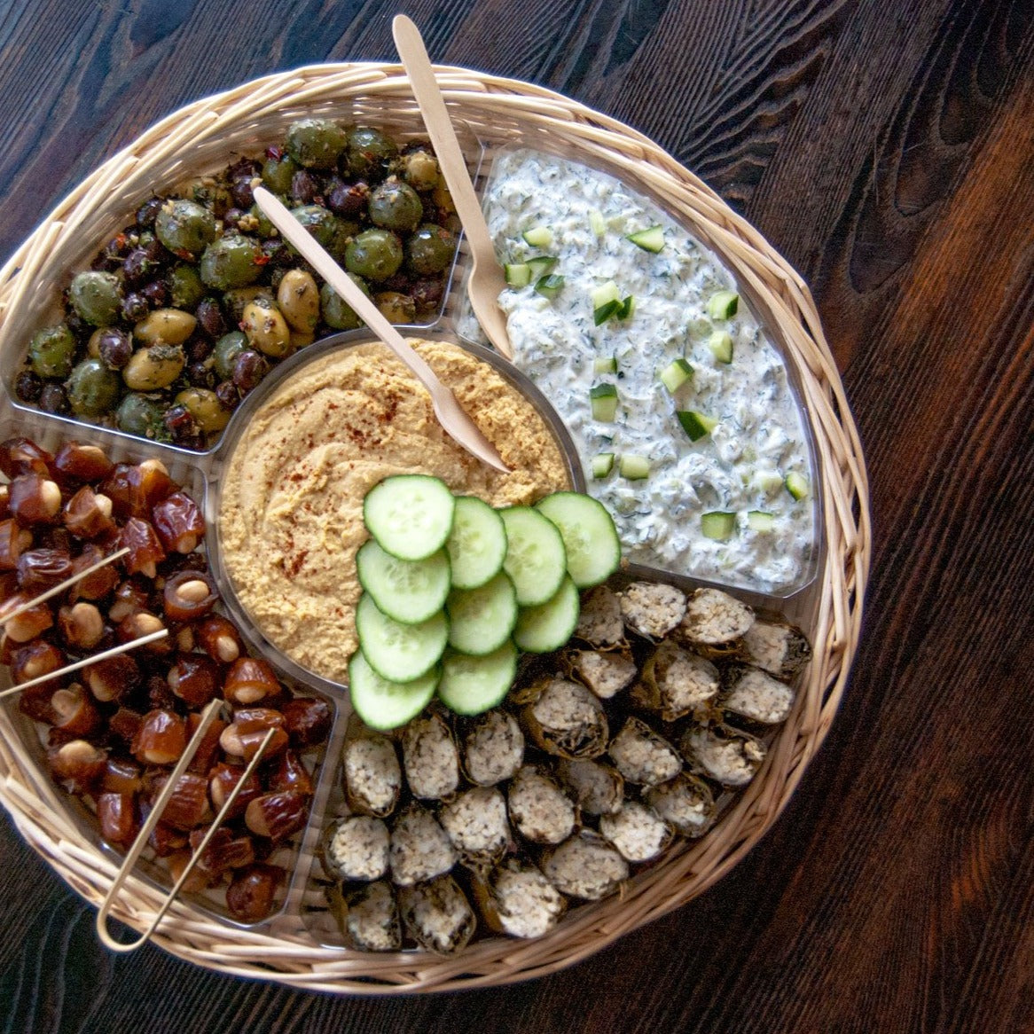Platter with dolmas, hummus, tzatziki, olives, and almond stuffed dates