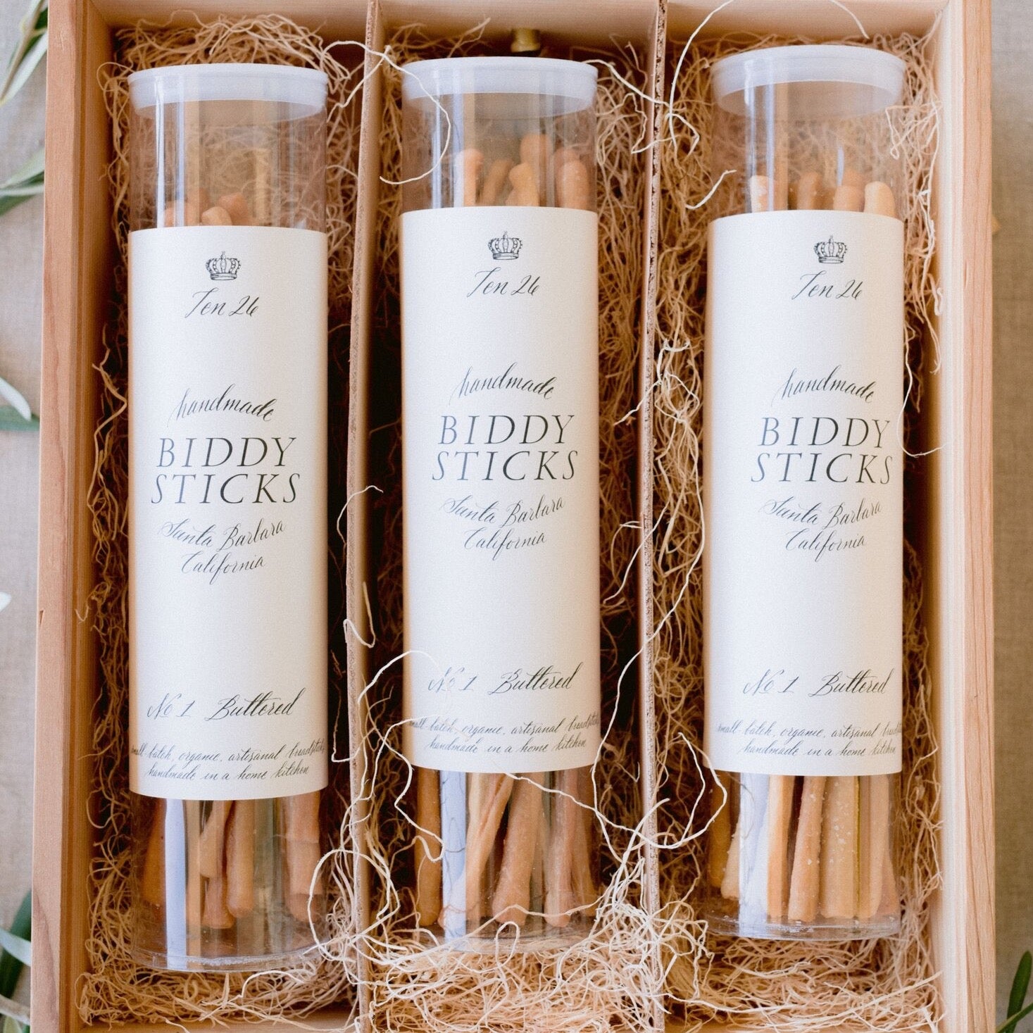 Three containers of breadsticks in a wooden box