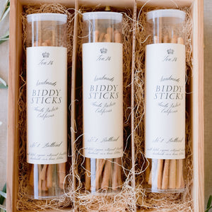 Three containers of breadsticks in a wooden box