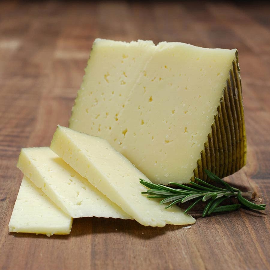 Wedge of firm cheese with green rind