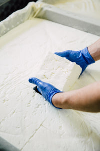 man cutting feta blocks