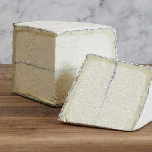 Wheel of soft goat's cheese with ash running down the center