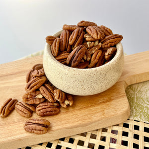 ceramic bowl of halved shelled pecans