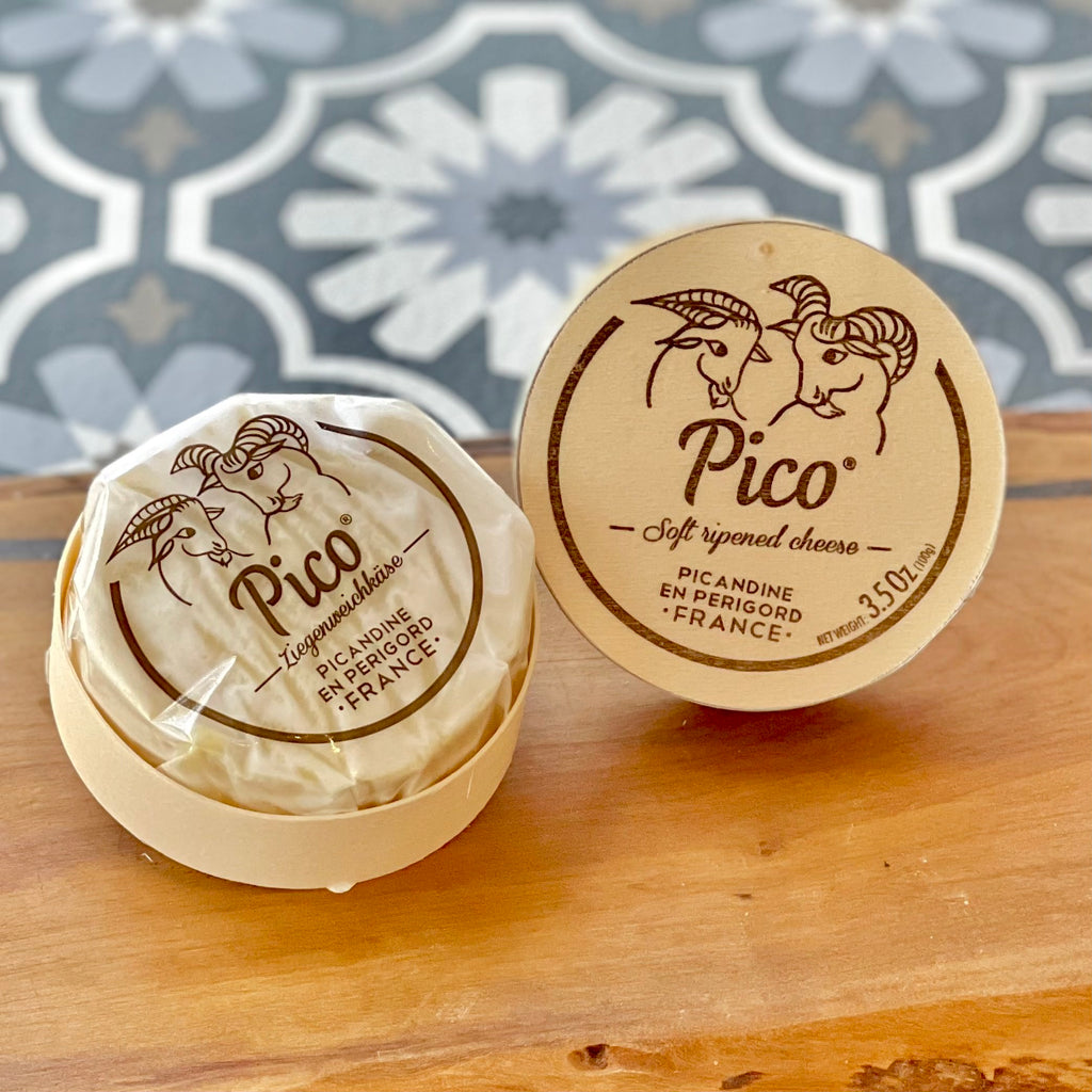 small wheel of goat's cheese in a wooden container