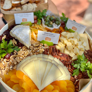 small cheese platter with dried fruits, nuts, grapes, and olives