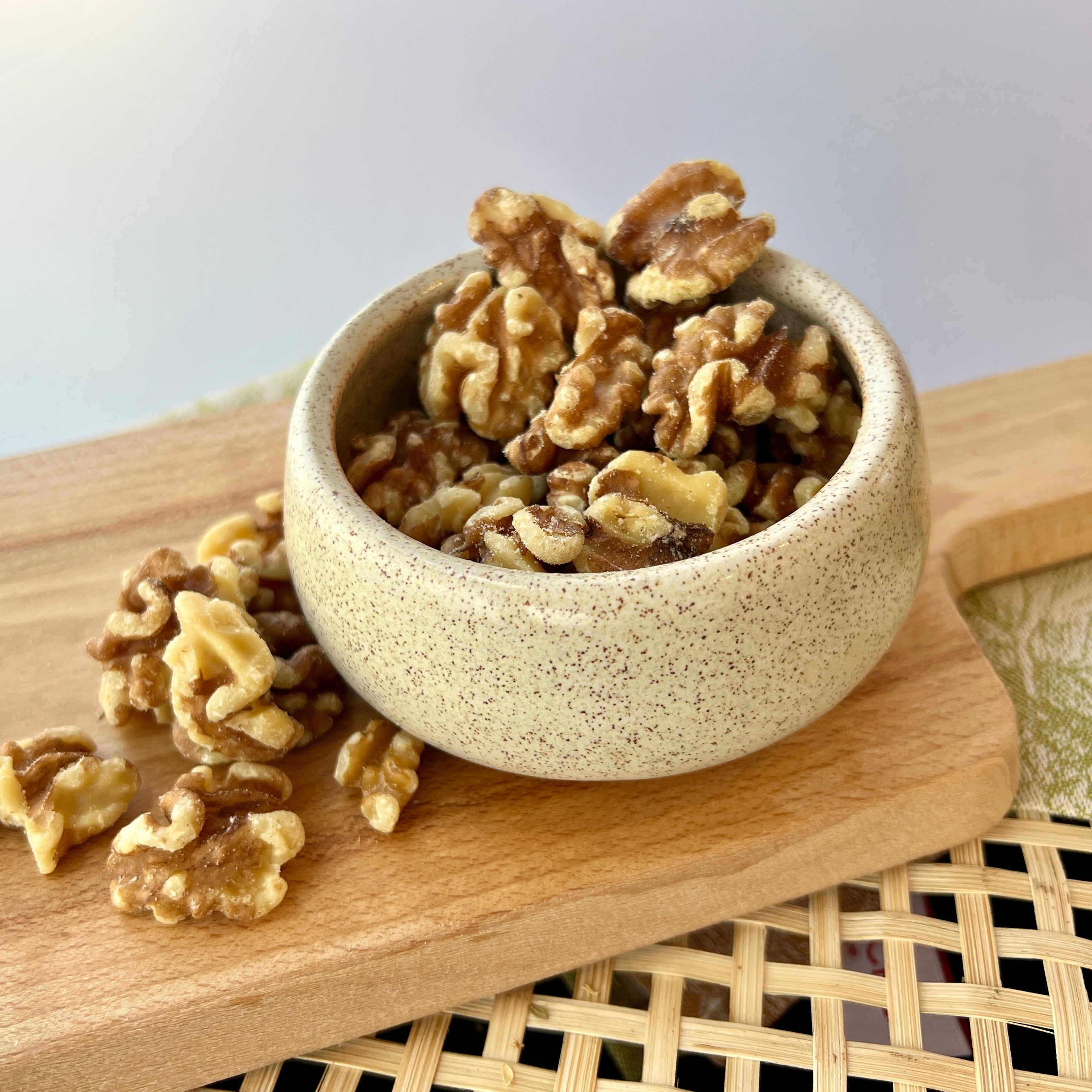 ceramic bowl of shelled halved walnuts